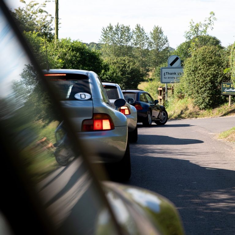 Z3 Coupé in Reihe Fahrzeugen auf einer kurvenreichen Landstraße in der Natur.